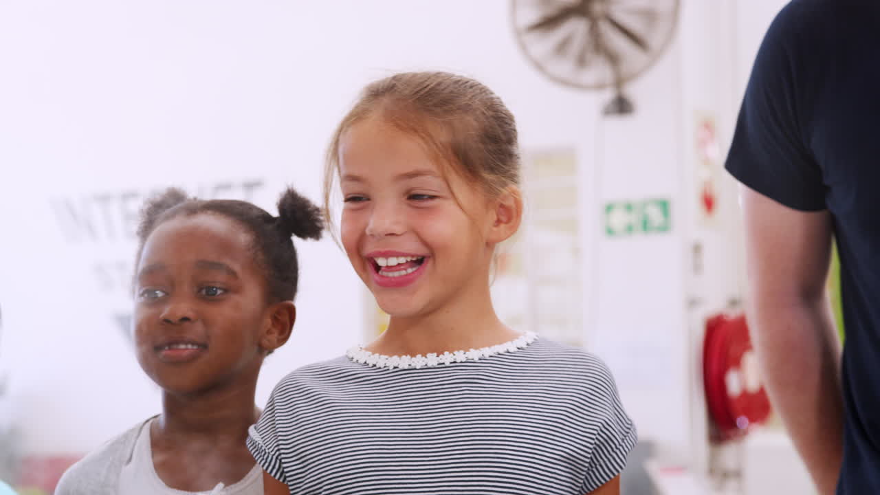 Crianças em idade escolar observando um experimento em um centro de ciências.