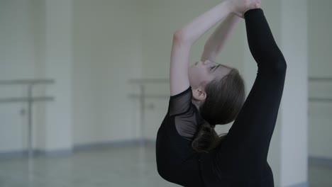 young ballerina practicing dance moves in studio