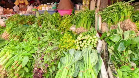 various vegetables displayed at a busy market stall