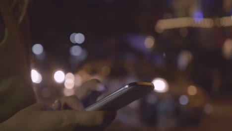 Nahaufnahme-Einer-Frau,-Die-Mit-Mobiltelefonen-Auf-Bokeh-Hintergrund-Schreibt