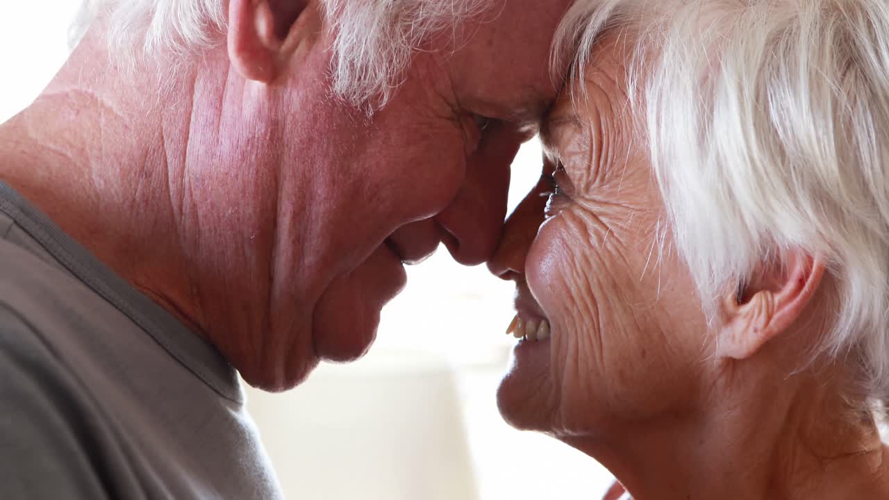 Coppia anziana felice in momenti romantici in camera da letto