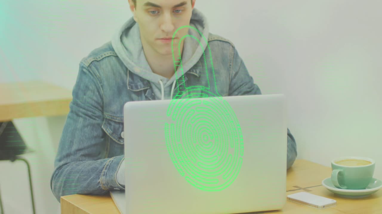 animación de huella dactilar en un candado sobre un hombre caucásico trabajando en una computadora portátil con una taza de café en la mesa.