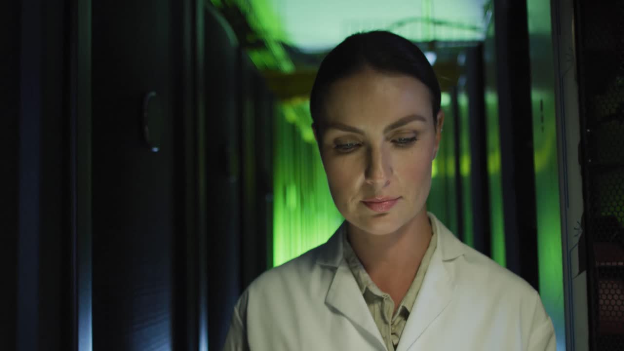 técnica informática caucásica en bata de laboratorio usando una tableta comprobando el servidor de la computadora