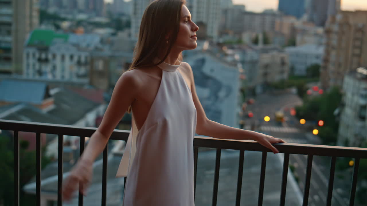 Attractive model posing balcony at twilight city view closeup. Relaxed woman