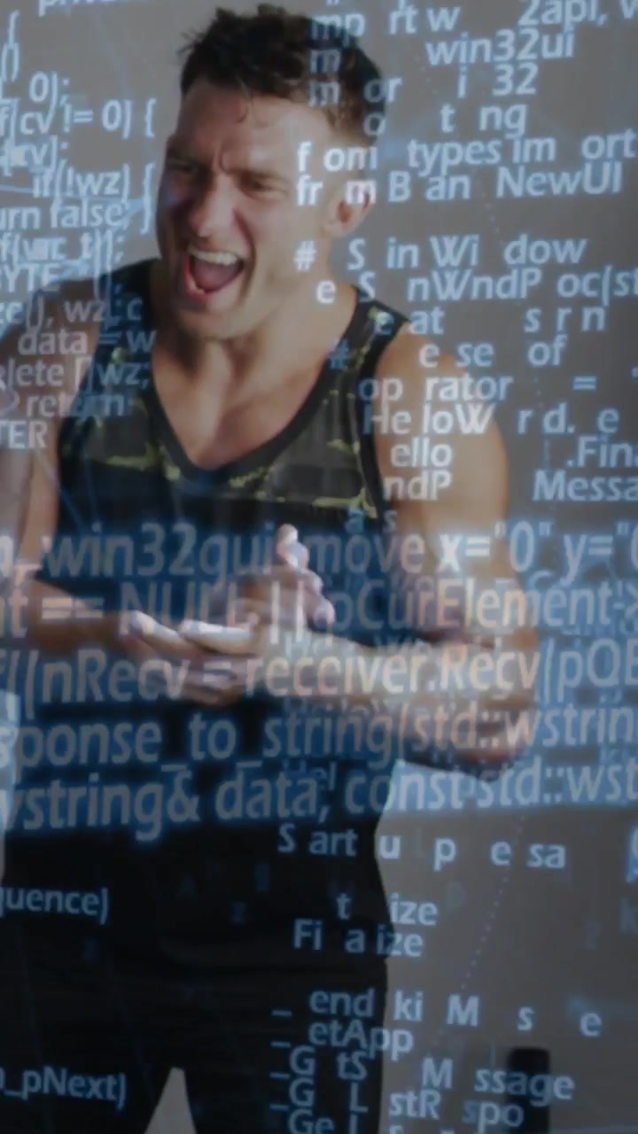 Hombre reaccionando a una señal fuera de cámara, aplaudiendo y riendo con una superposición de código tecnológico sobre él.