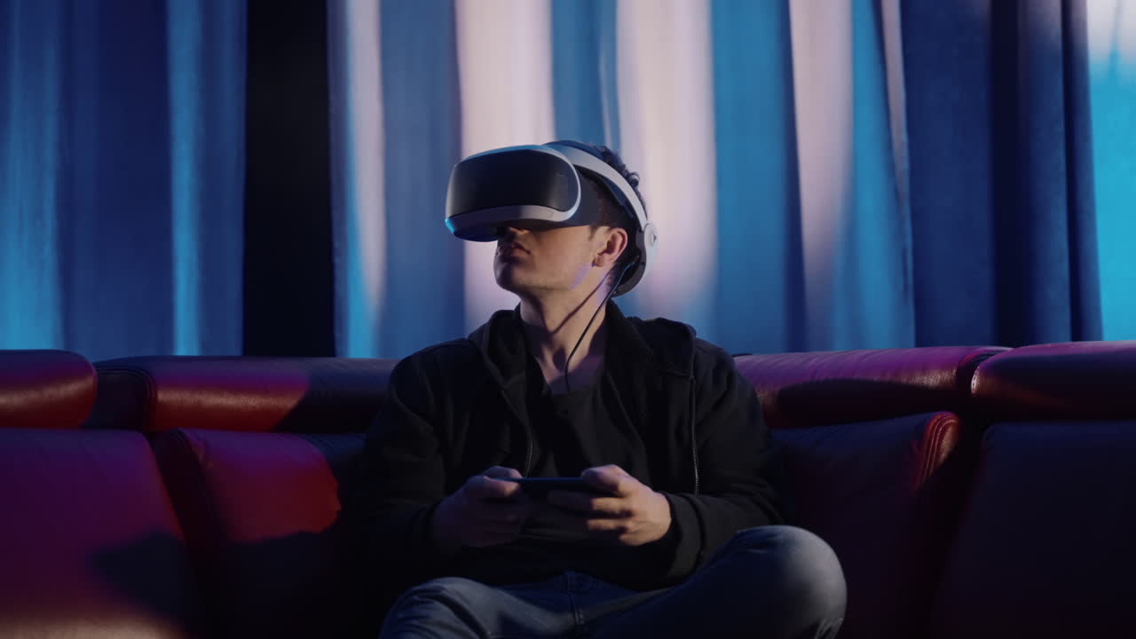 Uomo che gioca a un videogioco VR sul divano.