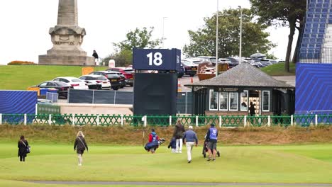 people walking towards golf course scoreboard