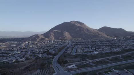 A-mesmerizing-drone-shot-circles-Blue-Mountain,-gradually-unveiling-the-expansive-suburban-neighborhood-below,-showcasing-the-impressive-scale-of-the-surroundings