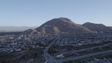a mesmerizing drone shot circles blue mountain, gradually unveiling the expansive suburban neighborhood below, showcasing the impressive scale of the surroundings