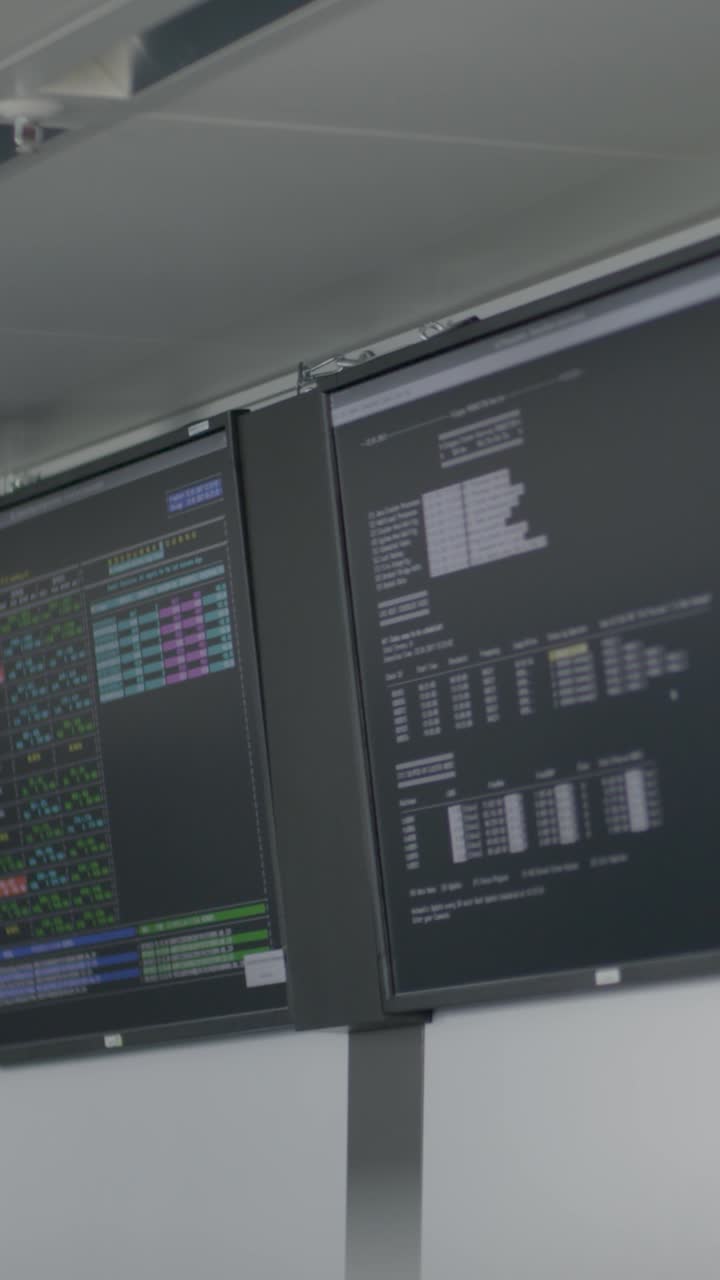 Stock market data displays on vertical monitors in an office setting
