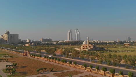 aerial flyover jiger shah park with com3 mall in the background in karachi. follow shot