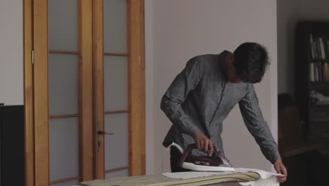 Young-Sri-Lankan-businessman-shirt-ironing-his-clothes-in-the-apartment