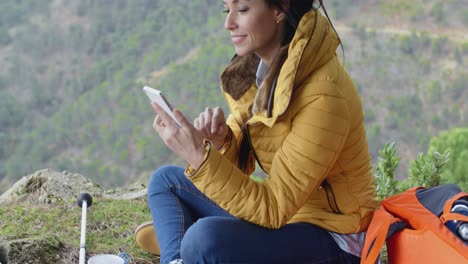 Smiling-female-hiker-using-her-phone