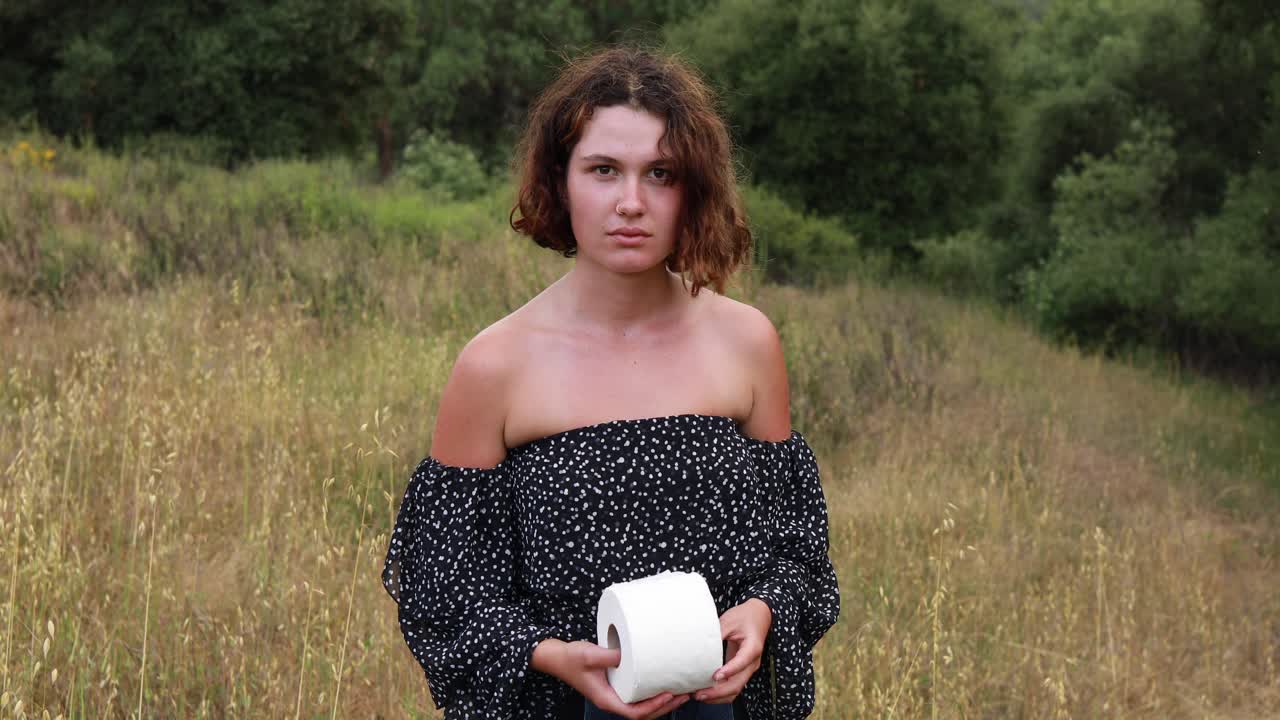 женщина ловит рулон туалетной бумаги tp в поле во время эпидемии пандемии коронавируса covid19