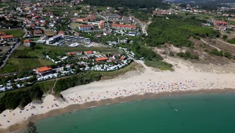 Aerial-Pan-Shot-of-a-Beautiful-Coast-Landscape-over-a-Crowded-Beach-and-Resort