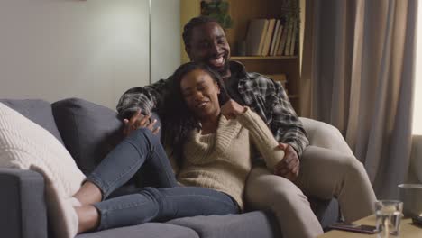 Loving-Couple-Relaxing-At-Home-Sitting-On-Sofa-Talking-Together-3