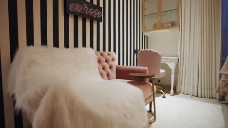 a stylish room featuring a pink quilted sofa adorned with a soft plush throw blanket - pan up shot