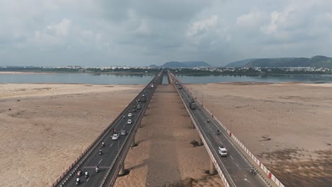 this aerial video captures the city's vibrant urban landscape, where the majestic krishna river gracefully winds its way through the landscape, intersecting the chennai-kolkata highway bridge