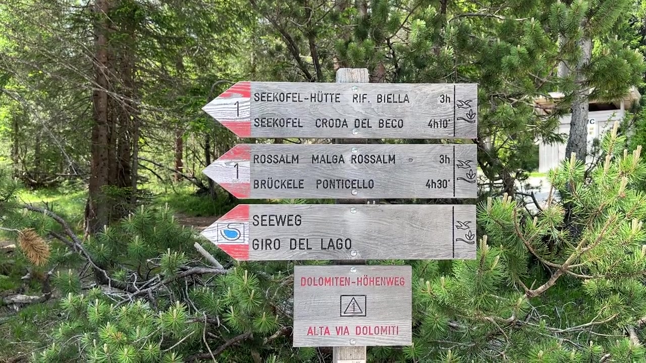 Close up footage of a hiking trail sign at the stunning Lago di Braies, one of the most iconic and popular hiking destinations in the Dolomites, South Tyrol, northern Italy.