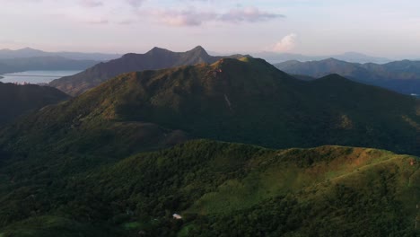 Aerial-view-flying-towards-majestic-lush-tropical-Kowloon-mountain-range-valleys-landscape-Hong-Kong