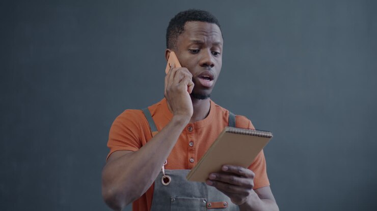 Man talking on phone and taking notes