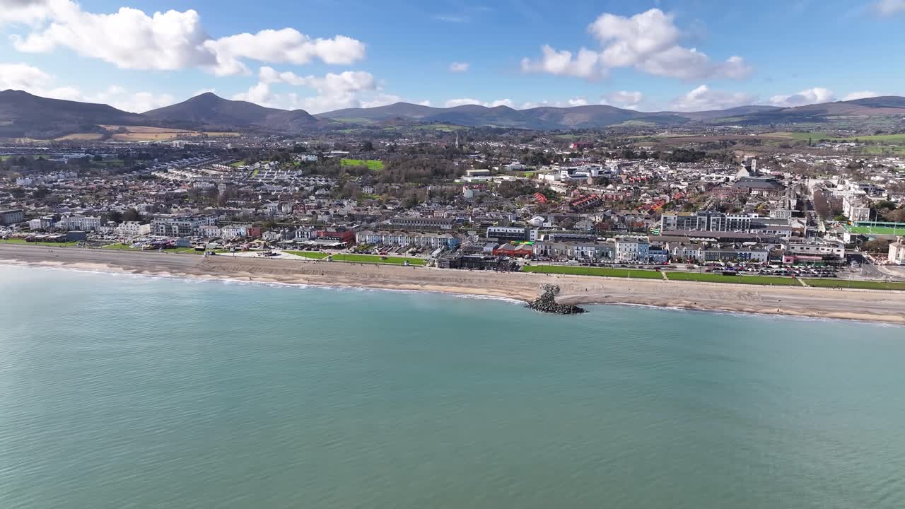 Bredt dronelandskap over Bray-stranden og kystbyen, med Wicklow-fjellene i bakgrunnen. Irland.