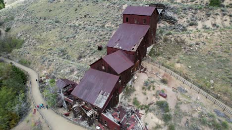 rusted gold mine and mill building, panoramic aerial view with people walking