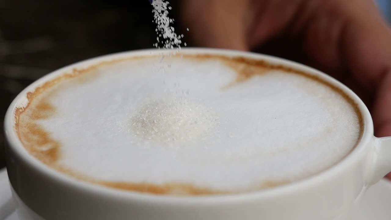 Adding sugar to a cappuccino