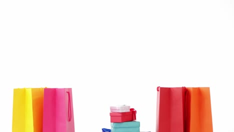 bolsas de compras multicolores con regalos envueltos contra un fondo blanco