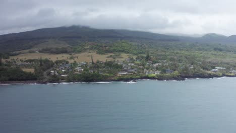 aerial low panning shot flying over hana bay towards the small town of hana on the windward coast of maui, hawai'i