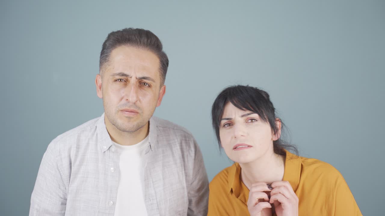 una pareja mirando a la cámara con curiosidad.