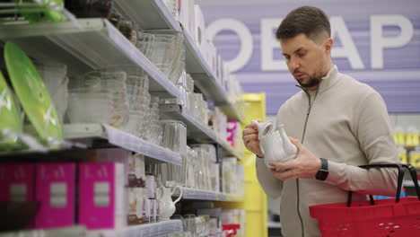 hombre comprando una tetera en una tienda de comestibles