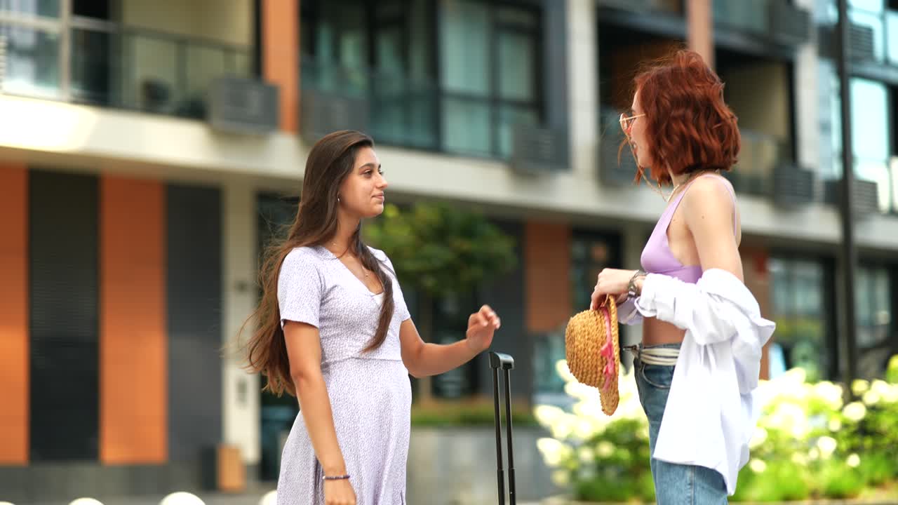 두 명의 젊은 여성들이 야외에서 대화하고 있습니다.