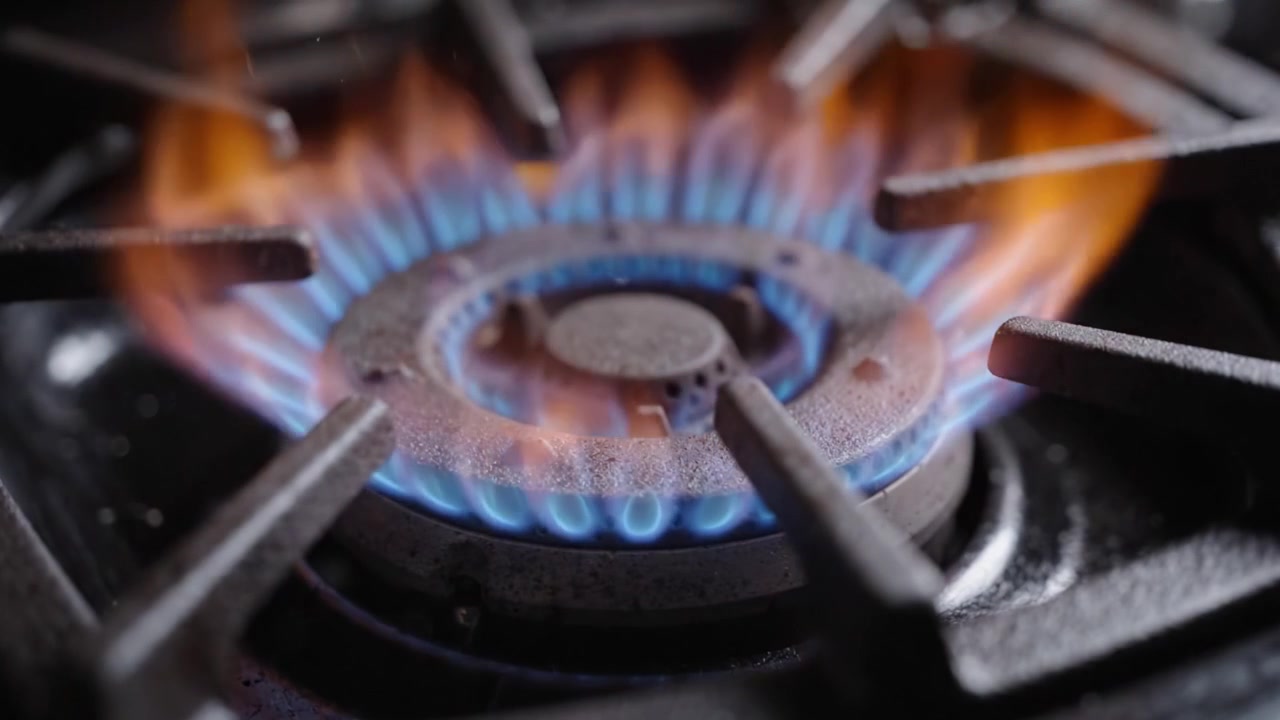 A Captivating View of a Gas Stove Igniting with a Vibrant Blue Flame, Showcasing the Power and Precision of Culinary Equipment in Action