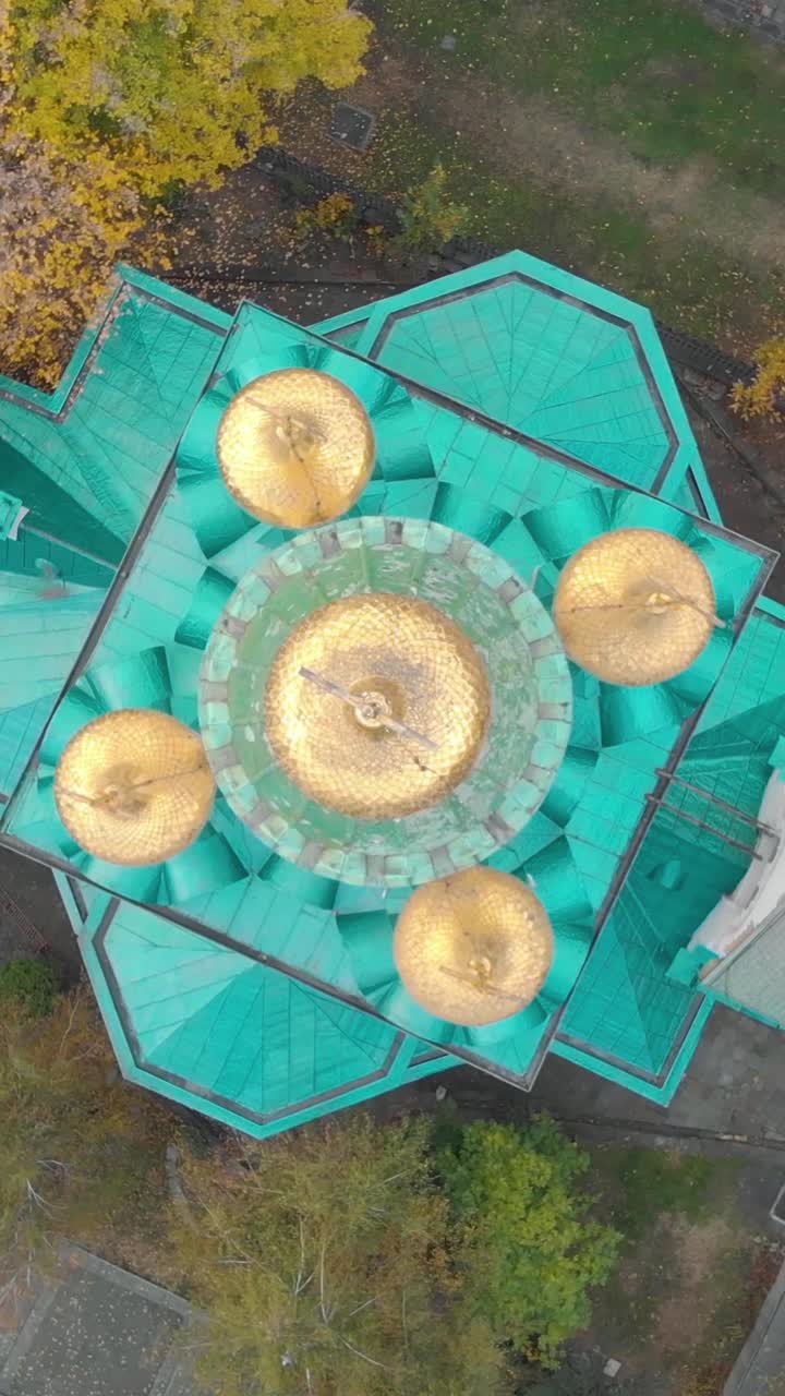 Golden domes of Saint Nikolas Russian Church are shining on a sunny day in Sofia, Bulgaria. Aerial, Birds Eye View, Vertical Video. Spinning Shot