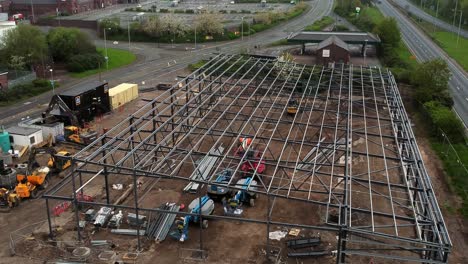 aerial rising view of aldi supermarket site foundation steel framework and construction equipment