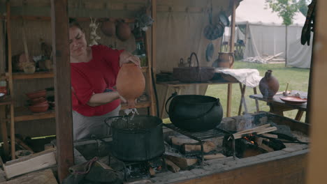 medieval woman cooking over a fire
