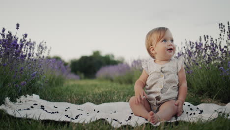 Portrait-of-a-carefree-child-in-a-lavender-field.-Girl-sits-near-tall-lavanlin-bushes