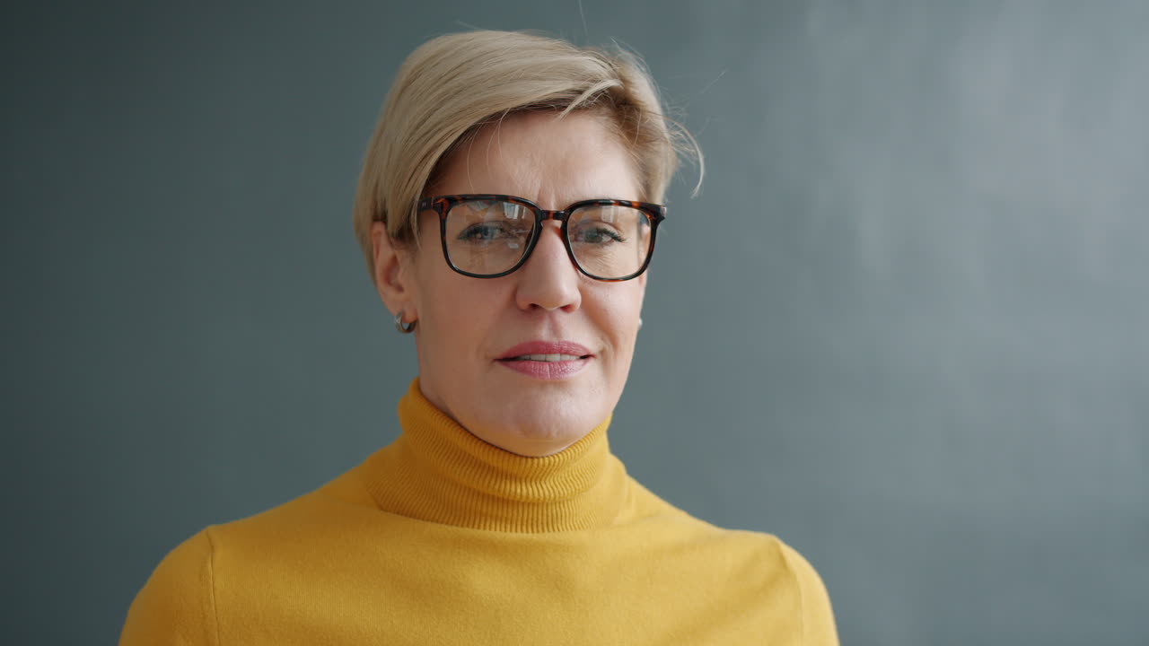 Portrait of a woman wearing glasses and a yellow sweater