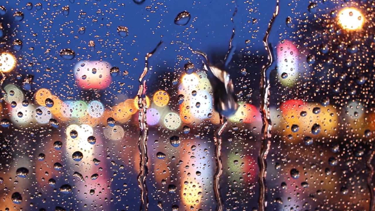 Ein regnerischer Abend mit farbenfrohem Bokeh: Die Essenz von Regentropfen auf Glas einfangen, eine verträumte Atmosphäre mit lebendigen Lichtern und Reflexionen im Hintergrund schaffen.