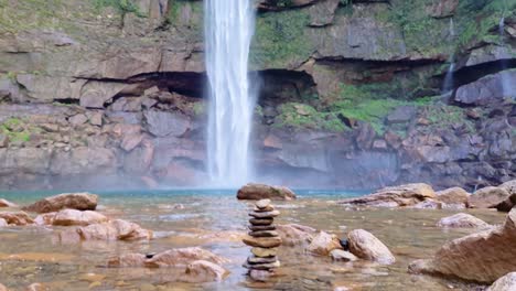 cascada natural que cae de la montaña con montones de piedras en el día
