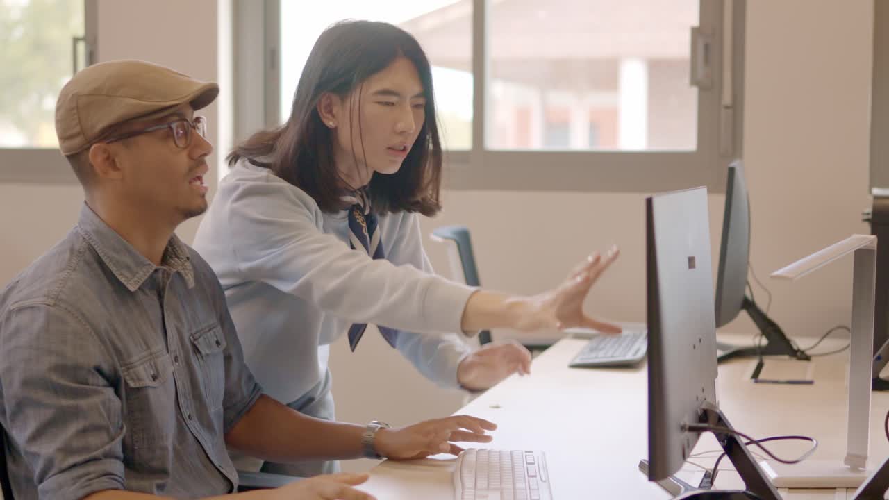 Designers talking while using computer in a coworking