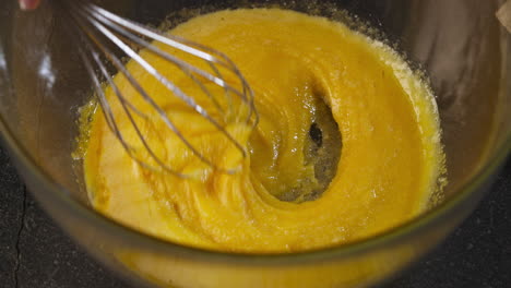 hands adding sugar while stirring a pastry dough. slow motion