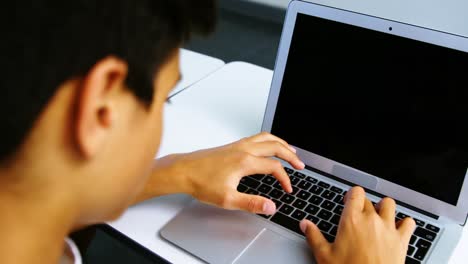 estudiantes que usan tabletas digitales y computadoras portátiles en el aula