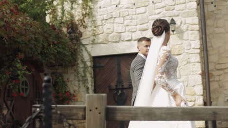 a bride and groom walk down a path in front of a stone castle.