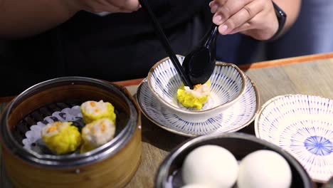 sirviendo albóndigas de dim sum con cuidado y precisión