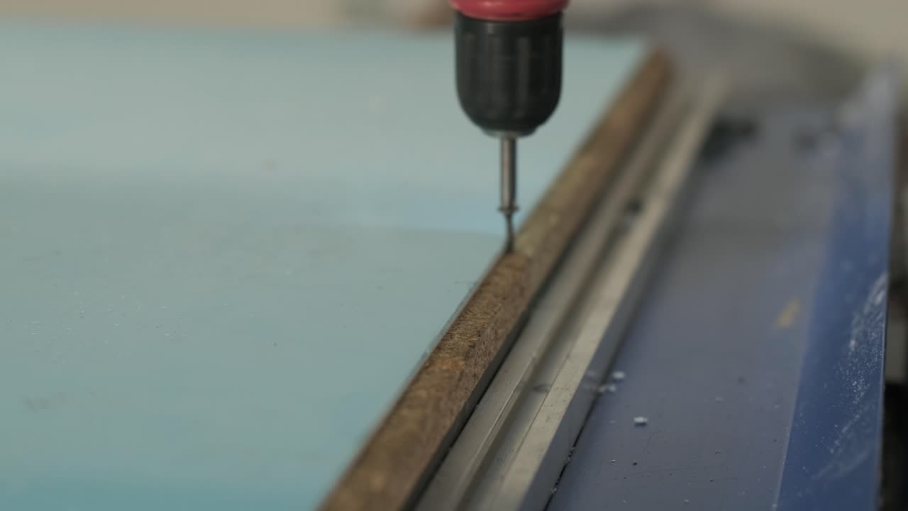 producción de carteles publicitarios en la fábrica. destornillador aprieta el tornillo