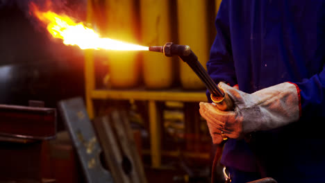 ingeniero masculino usando una antorcha de velding en el taller 4k