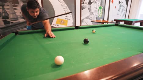 casual player pocketing the 8 ball winning the american style eight ball game in slow motion