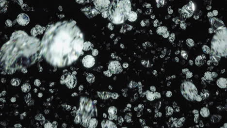 diamonds rotating and falling towards camera lens against black background in slow motion